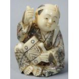 A Japanese Ivory Netsuke, carved and painted as a drummer, signed, height 5.5 cm.