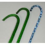 Two green coloured glass walking canes of rope twist design, together with another glass walking