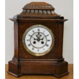A Victorian oak mantle clock, with white enamel two part dial and visible escapement, the French