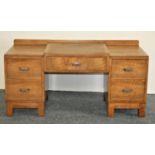 Heals; a child's light oak dressing table, button tab to right hand drawer, the stepped central