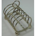 A silver six division toast rack, by Elkington & Co., Birmingham 1928, of plain form, raised on ball