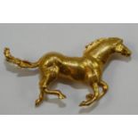 A 9ct gold galloping horse brooch, length 40 mm, weight 7.5 gms.