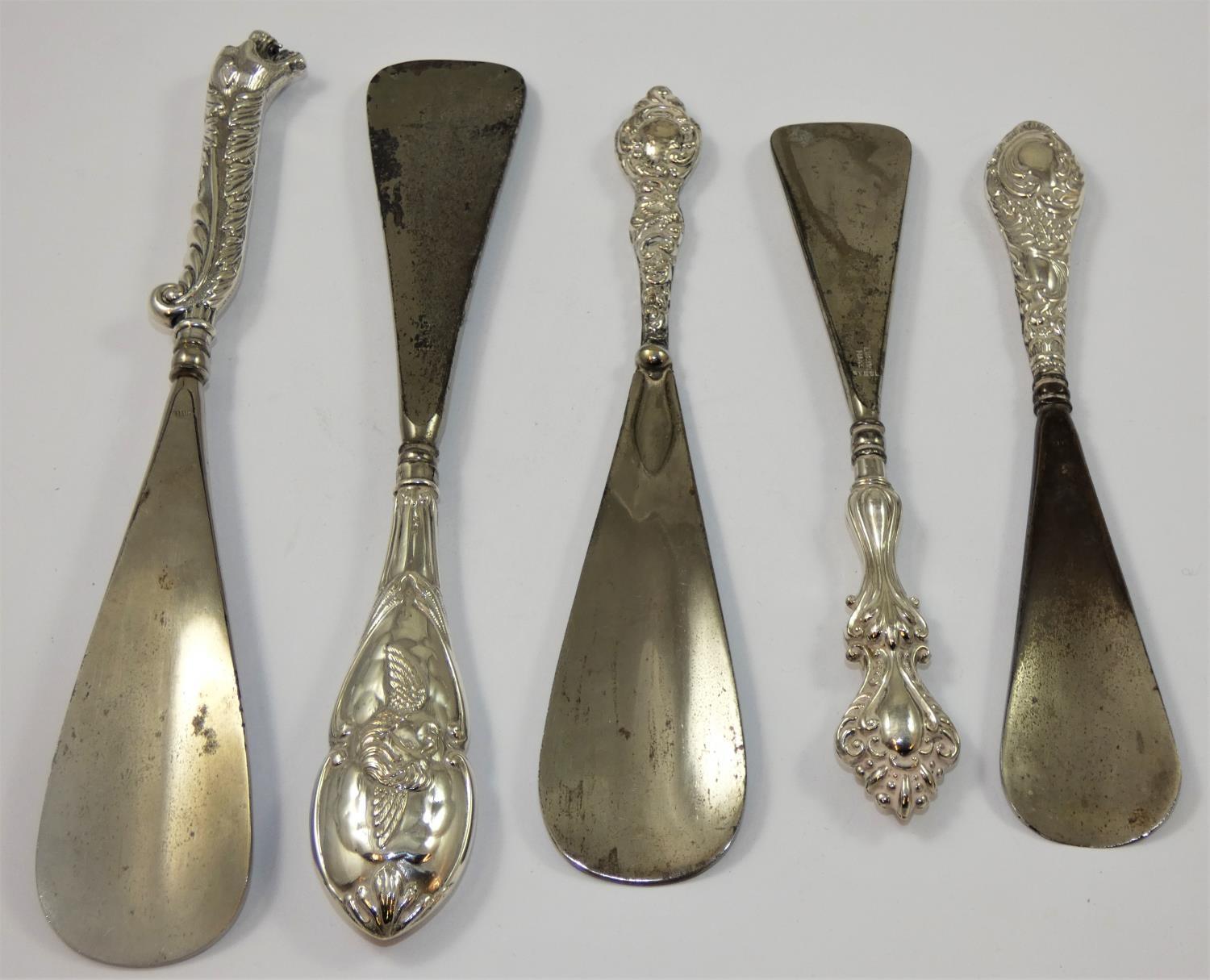 An Edwardian silver mounted shoe horn, Birmingham 1903, with embossed winged cherub decoration, a