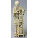 A Japanese Meiji Period Ivory Okimono, carved to depict a man tending a a vase of chrysanthemums,