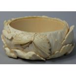 A Chinese Ivory bangle, carved with floral and butterfly decoration, inner size 7 x 6.5 cm.