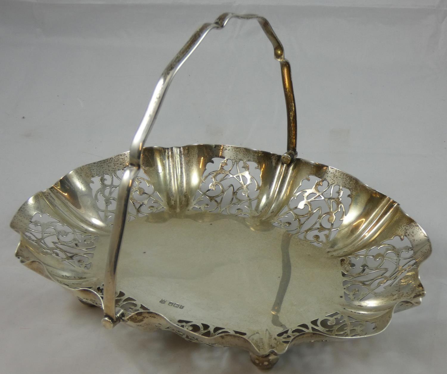 A silver swing handle basket, Sheffield 1911, of oval form with pierced border, raised on four