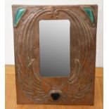 An Arts & Crafts copper easel mirror, with embossed angel wing decoration and three Ruskin pottery