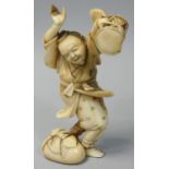 A Japanese Meiji Period Ivory Okimono, carved to depict a man with a drum, signed, height 11 cm.