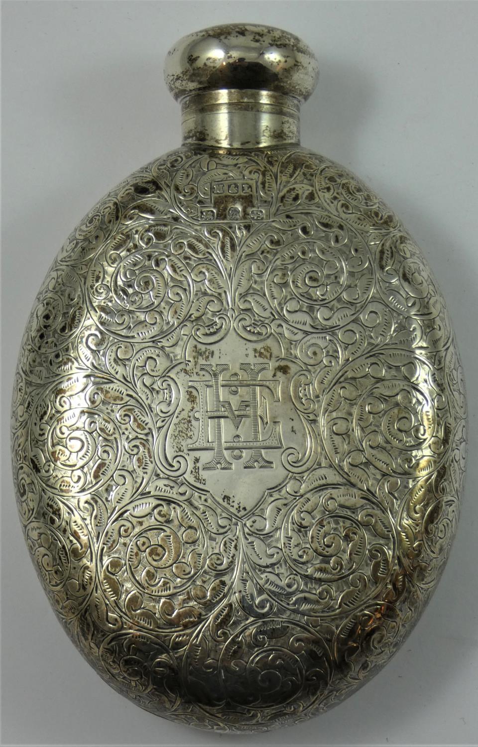 A Victorian silver hip flask, by M & L, Birmingham, 1896, of oval form with scroll engraved