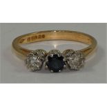 An 18ct gold sapphire and diamond three stone ring, claw set with brilliant cut stones, size O 1/2.