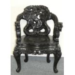 A Chinese carved hardwood armchair, with dragon backrest and arms, height 85 cm.