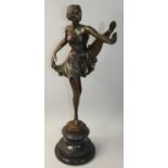 A Art Deco style French bronzed figure of a dancing girl posing with arm and leg extended, after