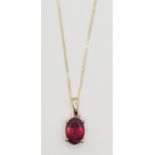 A 9ct gold ruby pendant, claw set with an oval mixed cut stone, chain.