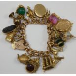 A 9ct rose gold multi charm hollow curb bracelet, mounted with various to include an enamel fob, a