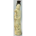 A Japanese ivory Okimono, in the form of a lady holding a vase of flowers, man riding a reindeer