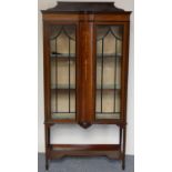 An Edwardian mahogany and boxwood inlaid display cabinet, the astragal glazed doors flanking a domed
