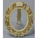 A 19th century Cantonese ivory photograph frame, carved with dragons, vacant cartouche, height 10