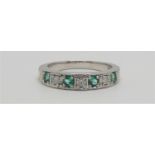 A 9ct white gold emerald and diamond half eternity ring, channel set with brilliant cut stones, size