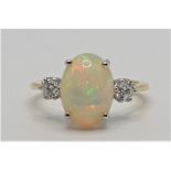 An 18ct gold opal and diamond three stone ring, claw set with a cabochon stone, measuring 13 x 8 mm,