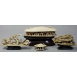 A Chinese Ivory clam shell, carved with figures and trees, length 12.5 cm, mounted on a hardwood