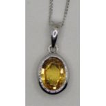 A 9ct white gold yellow sapphire pendant, collet set with an oval mixed cut stone, chain.