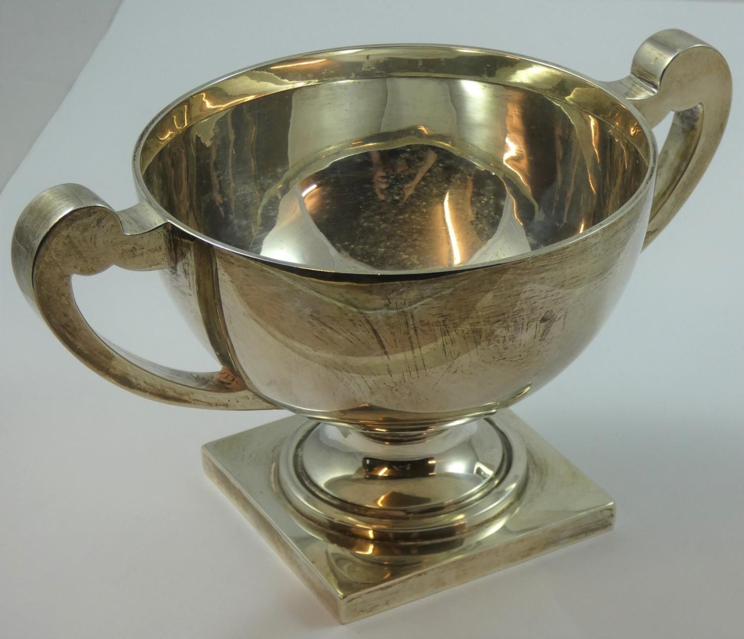 A silver two handled trophy bowl, Birmingham 1924, of plain form, raised on a pedestal foot,