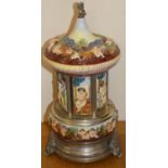 A polychrome porcelain and electroplate cigarette dispenser carousel, decorated with raised