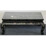 A Chinese black painted hardwood coffee table, the surface carved and poly chrome painted with