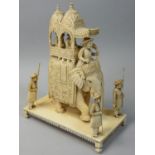 A 19th century Indian carved ivory figure of an elephant with two people in a Howdah, four