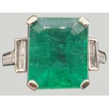 An 18 ct white gold emerald and diamond dress ring, claw set with a step cut stone, measuring 11.4 x