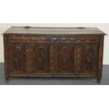 An 18th century and later oak coffer, the two plank lid with ornate wrought iron hinges, the front