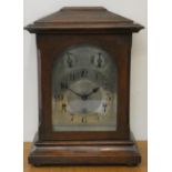 An Edwardian oak chiming mantle clock, the silvered dial with slow/fast and chime/silent dials,