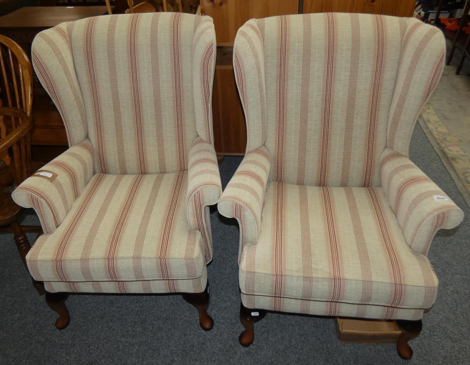 A pair of high backed winged armchairs (2).
