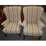 A pair of high backed winged armchairs (2).
