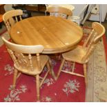 An extending pine dining table, together with a set of four pine dining chairs (5).