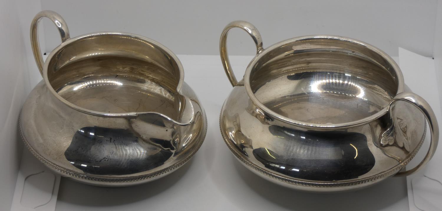 A silver sugar bowl and milk jug, Birmingham 1923, with gadrooned borders, 9.5 oz.