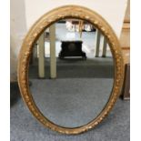 A gilt framed oval wall mirror, 77 x 54cm.