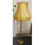 A brass standard lamp with shade.