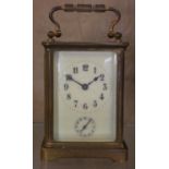 An early 20th century brass alarm carriage clock, white enamel dial, Roman numerals and subsidiary