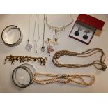 A quantity of costume jewellery to include a gilt metal charm bracelet.