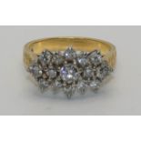 An 18ct gold and diamond cluster ring, panel set with brilliant cut stones, total weight