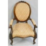A Victorian walnut parlour chair, with upholstered seat, back and arms, floral carved top rail,
