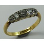 An Edwardian 18 ct gold and diamond five stone ring, channel set with graduated old cut