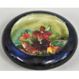 A Moorcroft Iris pattern pin dish, typically tube lined with flowerheads and leafy stems in shades