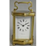A French brass Louis XV Doucine carriage timepiece, the white enamel dial with Roman numerals and
