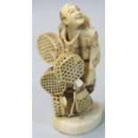 A Japanese Meiji Period Ivory Okimono, by Toshimasa, in the form of a street vendor carrying