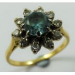 A blue zircon and diamond cluster ring, claw set with a brilliant cut stone, bordered by ten