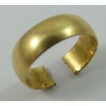 An 18ct gold wedding band, cut, 5 gms.