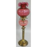 A late Victorian brass and glass oil lamp, with brass column, moulded ruby glass shade and