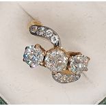 A three stone diamond ring, claw set with an old cut stone, estimated to weigh 0.75 cts, colour